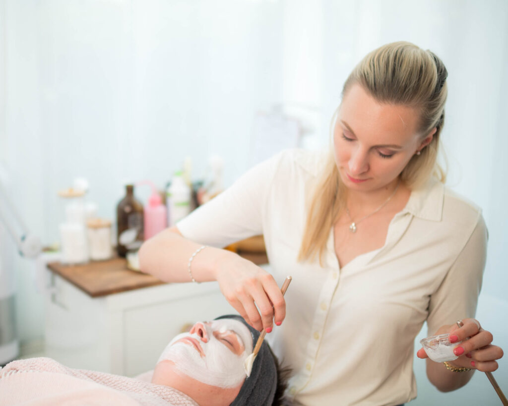 Auftragen einer hochwirksamen bio zertifizierten Wirkstoffreichen Maske auf gereinigte und vorbereitete Haut der Kundin im Kosmetikstudio Gilching.